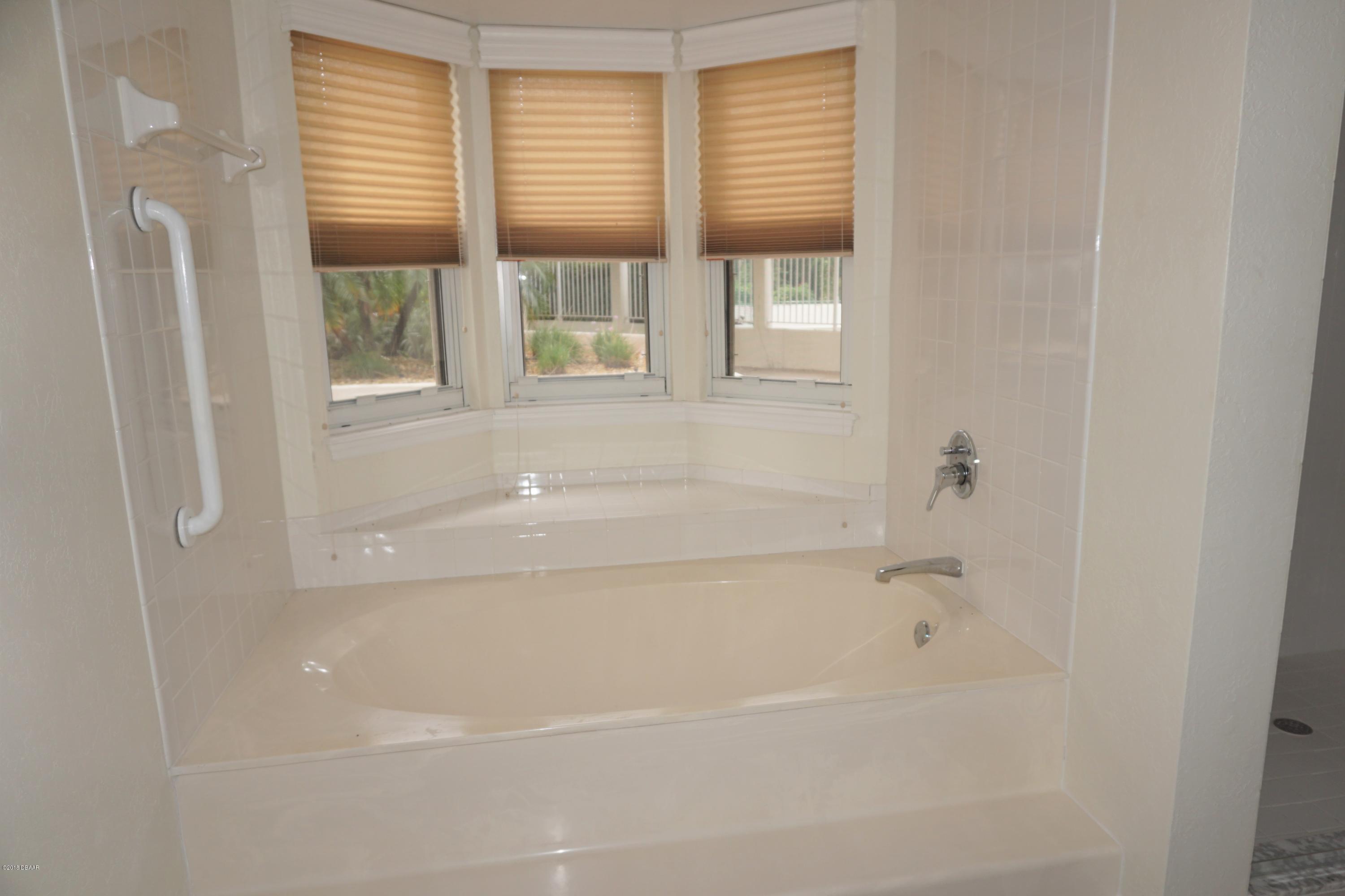 1 John Anderson Drive, Unit 113 Ormond Beach, FL 32176 - Photo 23 of 76 a close up of a bathtub with shower curtain
