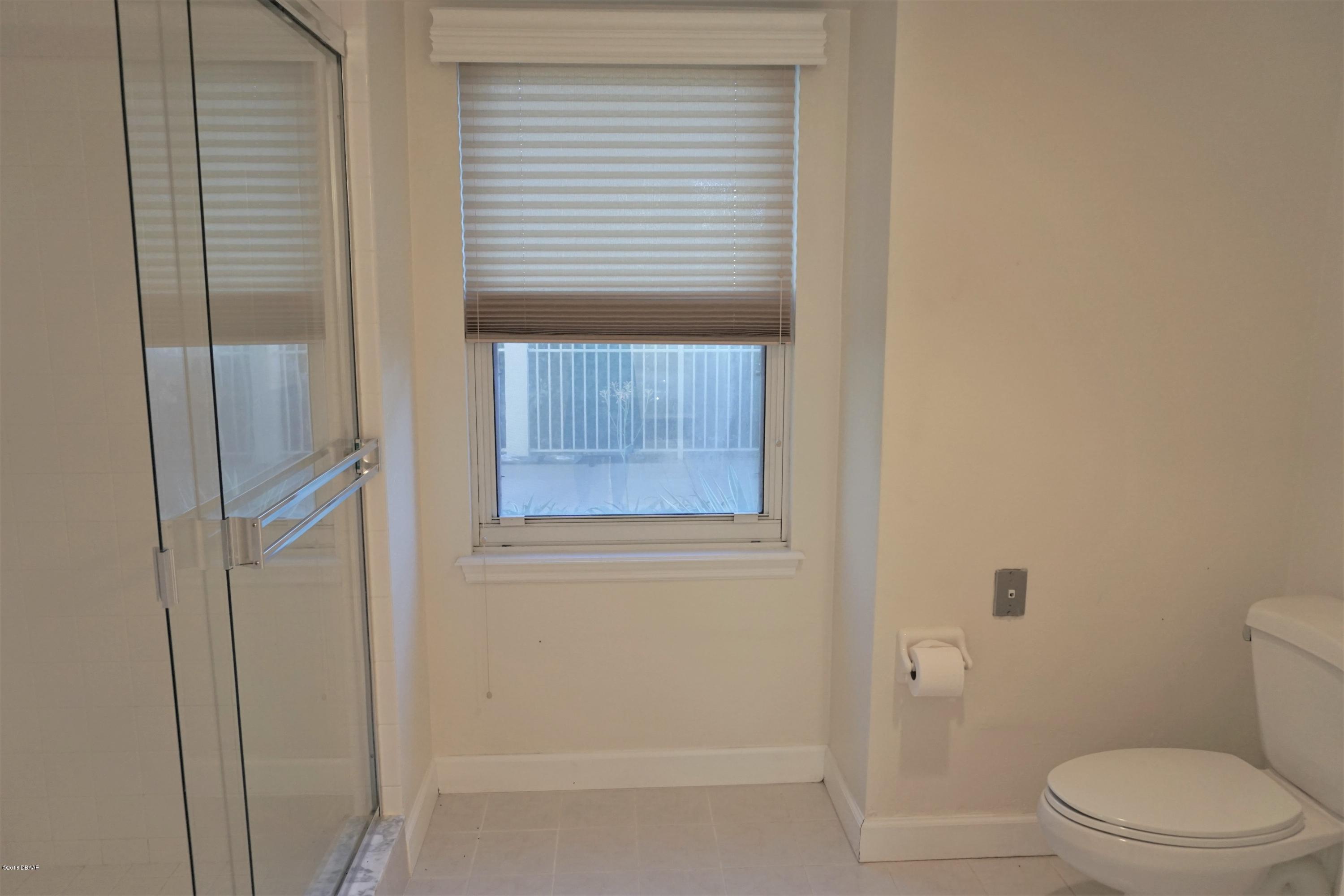 1 John Anderson Drive, Unit 113 Ormond Beach, FL 32176 - Photo 25 of 76 a bathroom with a toilet and a shower