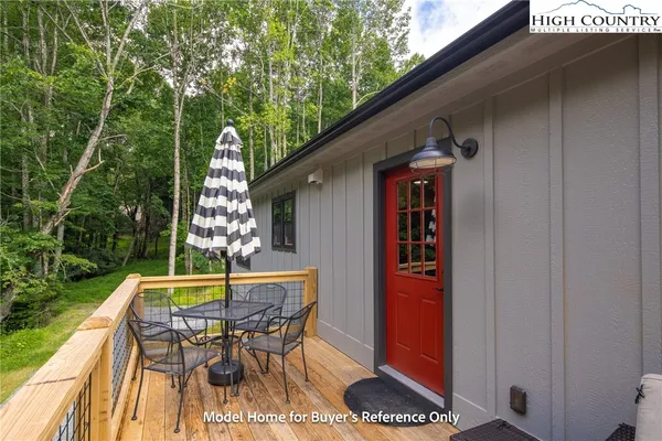 a patio with table and chairs and potted plants