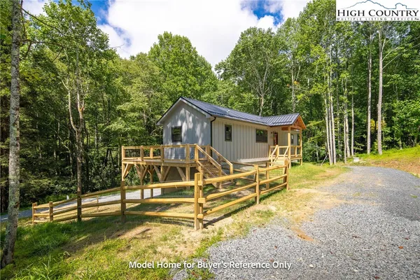a view of a house with backyard and a wooden fence