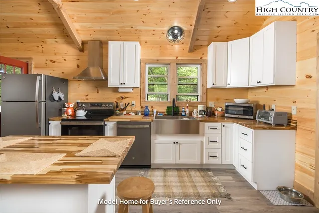 a kitchen with a stove a sink a refrigerator and cabinets