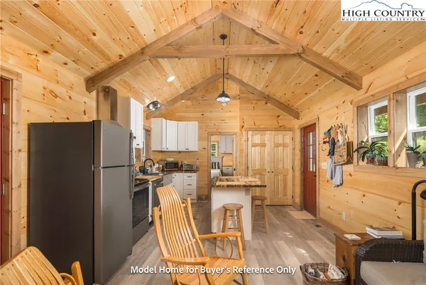 a view of a kitchen with refrigerator and wooden floor
