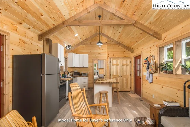 a view of a kitchen with refrigerator and wooden floor