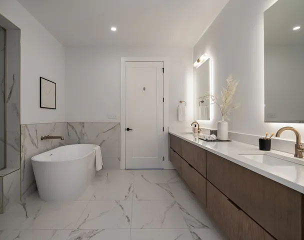 a spacious bathroom with a double vanity sink a mirror and a bathtub