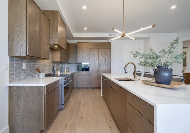 a kitchen with a sink a counter top space cabinets and stainless steel appliances