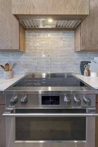 a stove top oven sitting inside of a kitchen