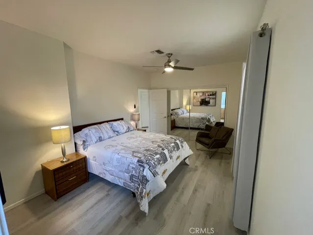 a bedroom with a bed and wooden floor