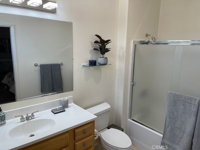a bathroom with a granite countertop toilet sink and mirror