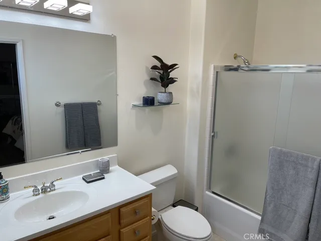 a bathroom with a granite countertop toilet sink and mirror