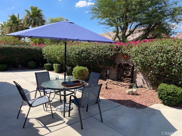 a view of a patio with table and chairs under an umbrella