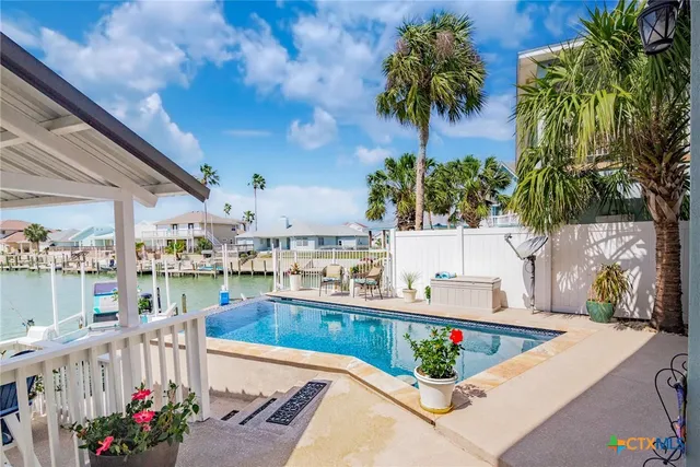 a view of a house with swimming pool and sitting area
