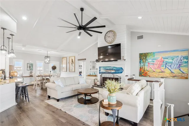 a living room with furniture a flat screen tv and a fireplace