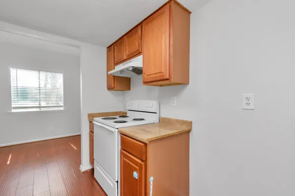 a kitchen that has a sink a stove and wooden floor