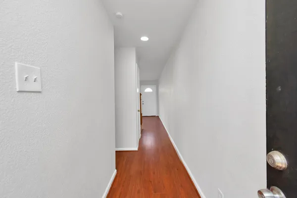 a view of a hallway with wooden floor