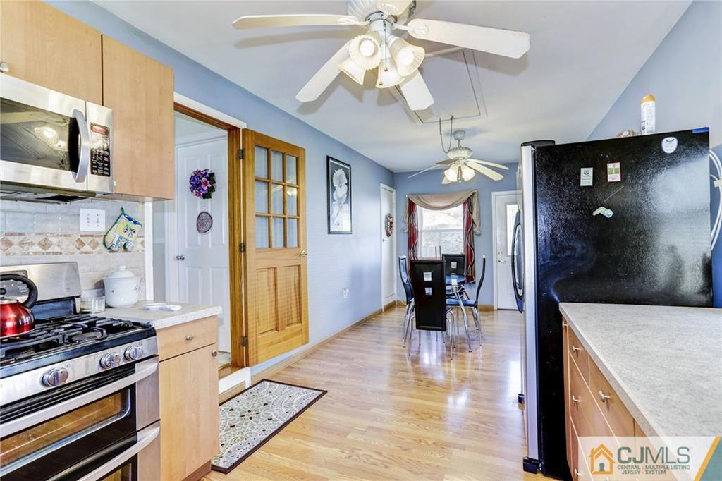 35 Clemson Road Old Bridge, NJ 08859 - Photo 13 of 25 a kitchen with stainless steel appliances granite countertop a stove top oven a sink dishwasher and white cabinets with wooden floor