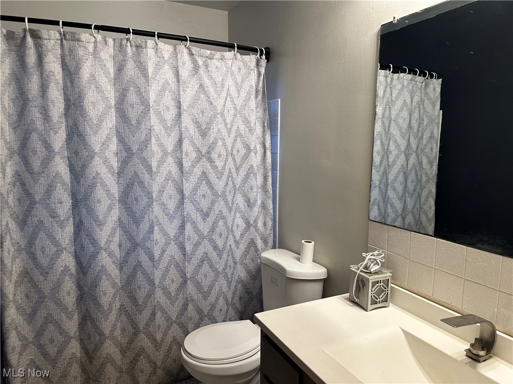 12303 Orme Road Garfield Heights, OH 44125 - Photo 17 of 22 Bathroom featuring toilet, vanity, and a shower with shower curtain