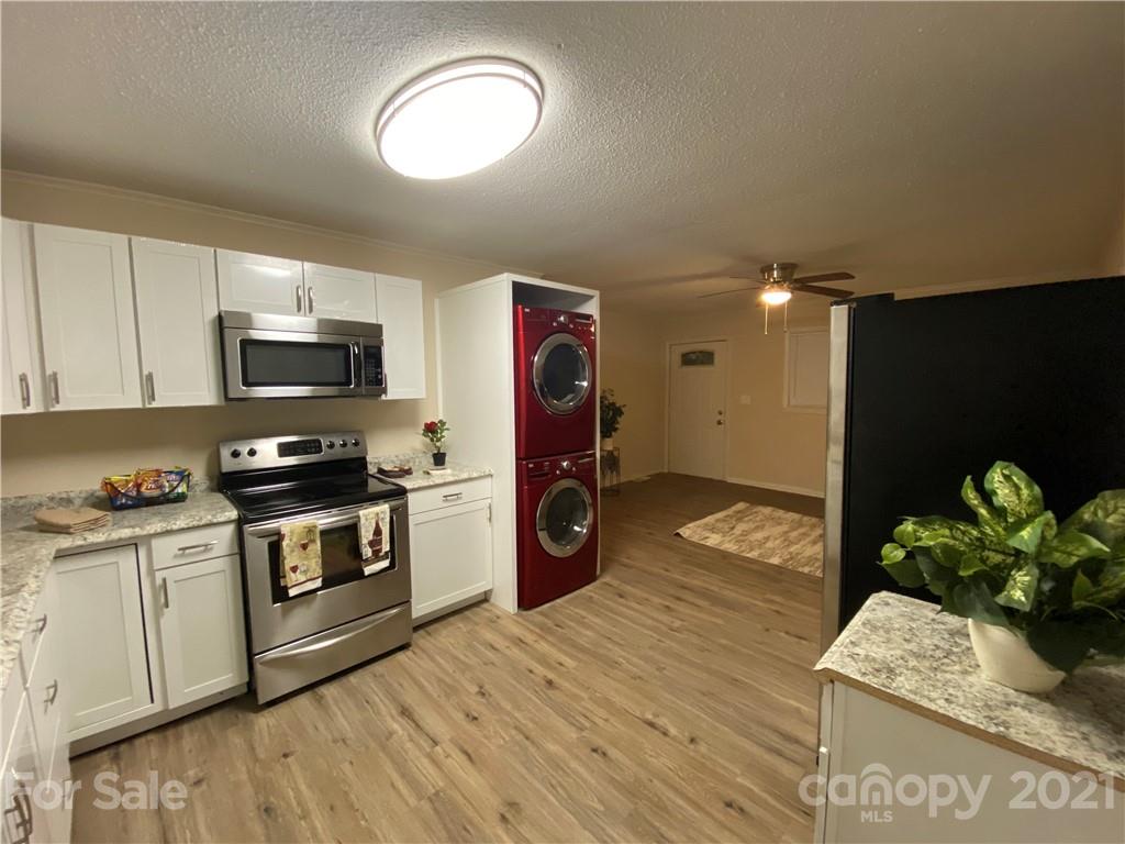 a kitchen with stainless steel appliances granite countertop a stove a sink and a microwave