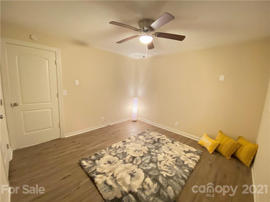 807 Park Road Dallas, NC 28034 - Photo 3 of 8 an empty room with wooden floor and fan
