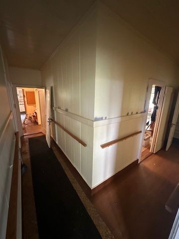 a walk in closet with wooden floor