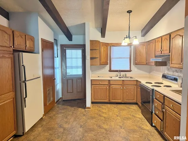 a kitchen with stainless steel appliances granite countertop a refrigerator a stove and a sink