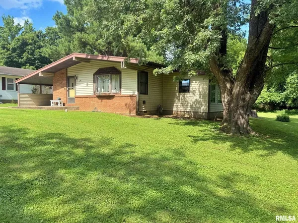 a front view of a house with yard and green space