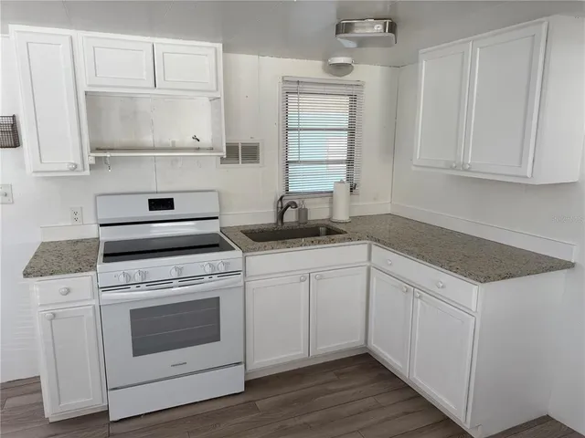 a kitchen with white cabinets and white appliances