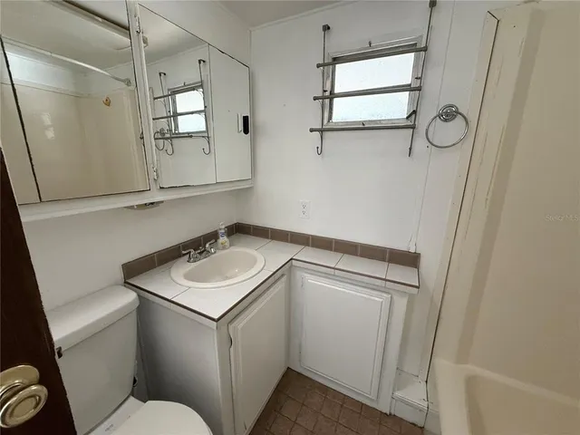 a bathroom with a sink toilet vanity and tub