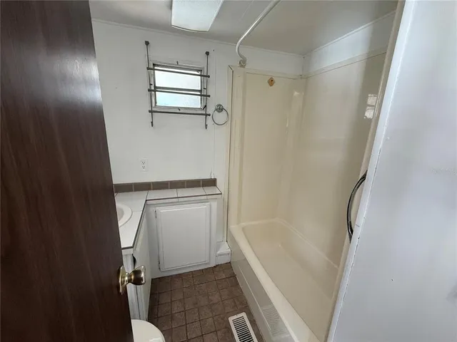 a bathroom with a tub shower and a sink