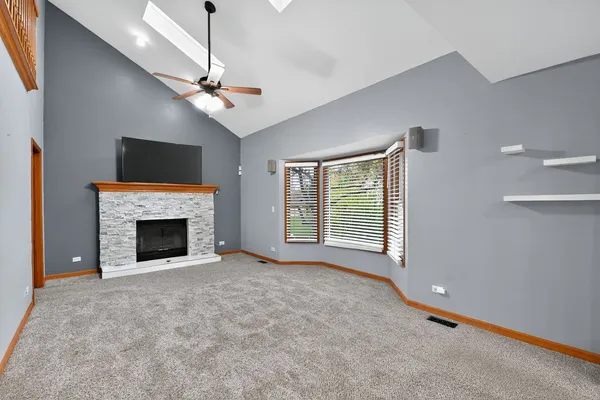 a view of a livingroom with a fireplace and ceiling fan