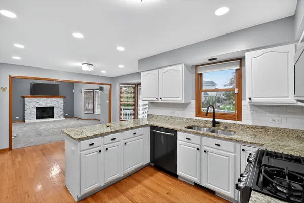 a kitchen with stainless steel appliances granite countertop a sink stove and cabinets
