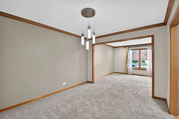 a view of a livingroom with a chandelier fan and a window