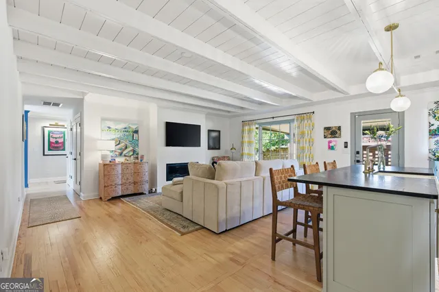 a living room with furniture a flat screen tv and a large window