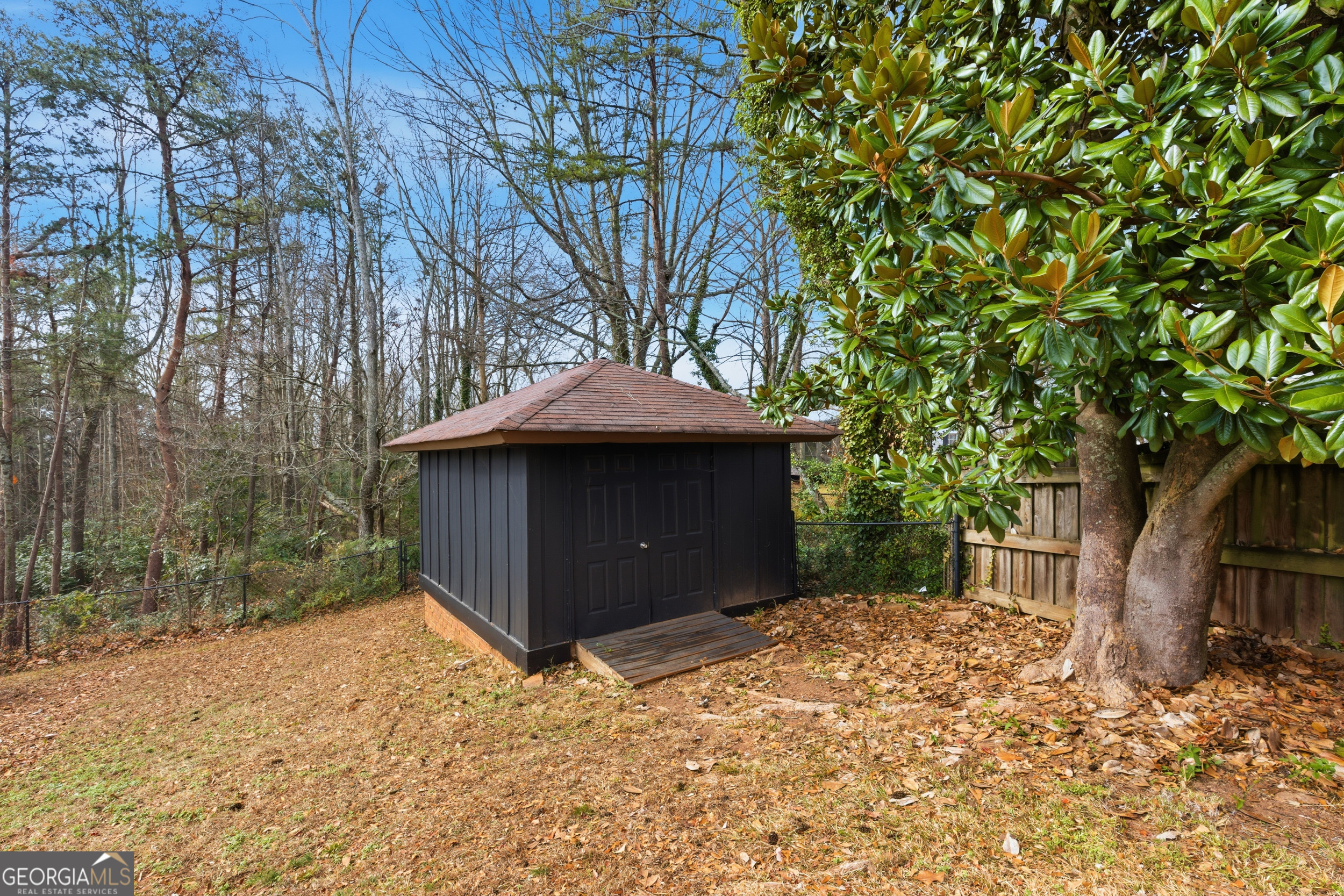 125 Maple Street Cornelia, GA 30531 - Photo 36 of 44 a backyard of a house with large trees and wooden fence
