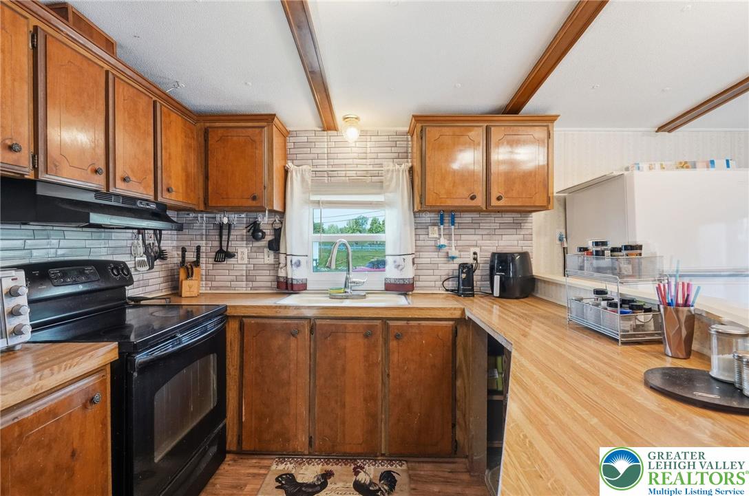 3101 Newburg Road Nazareth, PA 18064 - Photo 6 of 23 a kitchen with stainless steel appliances granite countertop a stove a sink dishwasher and a microwave oven with cabinets