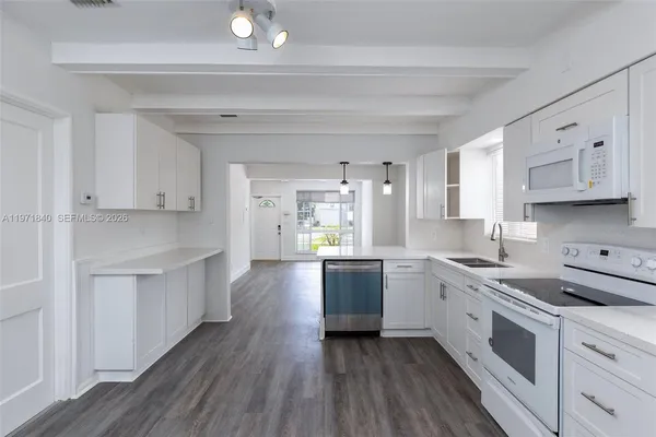 a large kitchen with stainless steel appliances lots of counter space and wooden floor