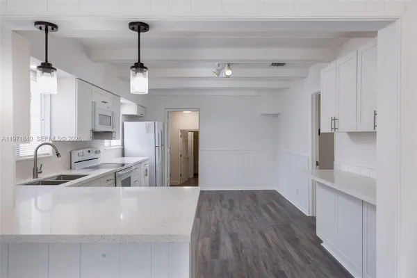 a view of a kitchen with a sink dishwasher a refrigerator and wooden floor