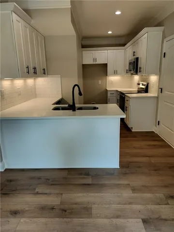 a kitchen with stainless steel appliances granite countertop a sink a stove and a refrigerator