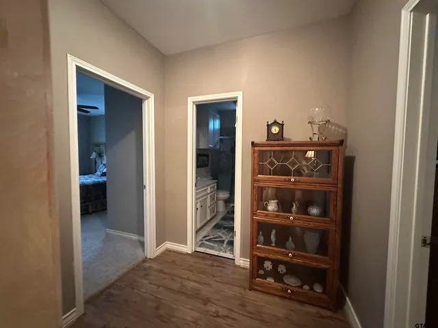 a view of a hallway with wooden floor and closet
