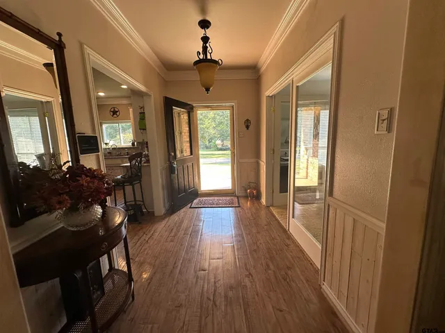 a view of a hallway with wooden floor and furniture