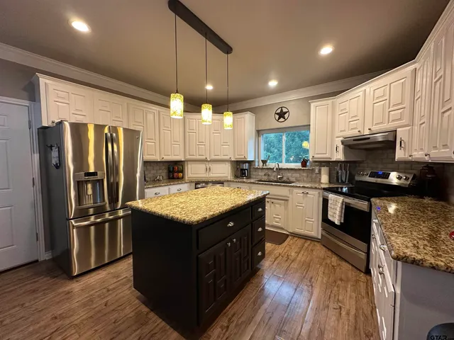 a kitchen with granite countertop stainless steel appliances and wooden cabinets
