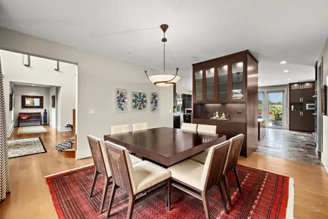 a dining room with furniture wooden floor a rug and a chandelier