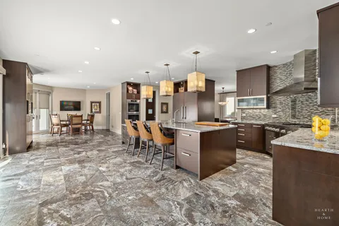 a large kitchen with a large counter top furniture a sink stainless steel appliances and cabinets