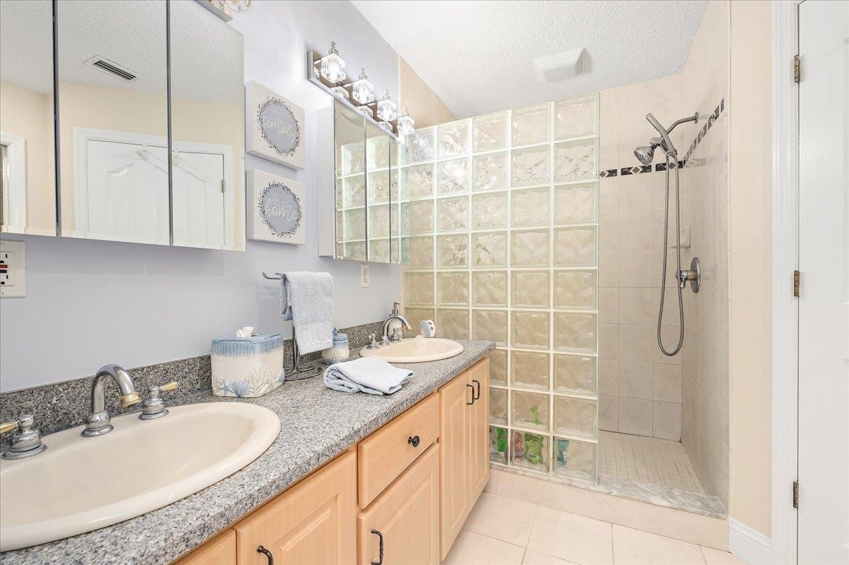 3180 B Pacetti Road St. Augustine, FL 32092 - Photo 13 of 42 a bathroom with a granite countertop sink a mirror and shower