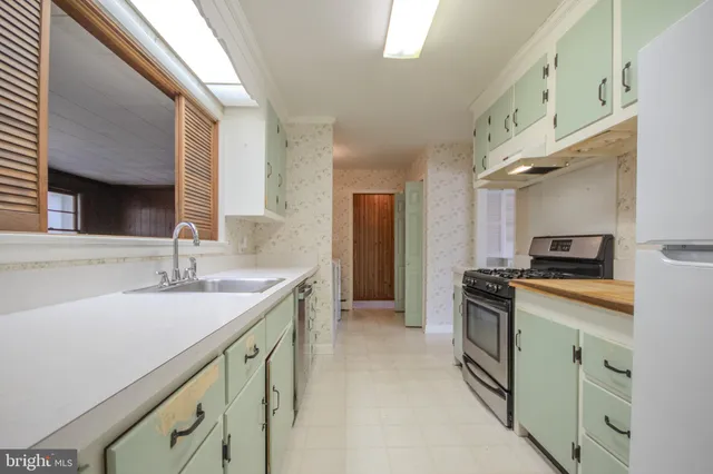 a kitchen with granite countertop a sink stove and cabinets