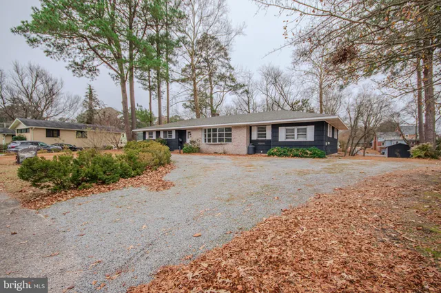 a view of residential houses with yard and trees