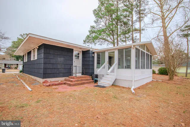 a front view of a house with a yard covered in snow