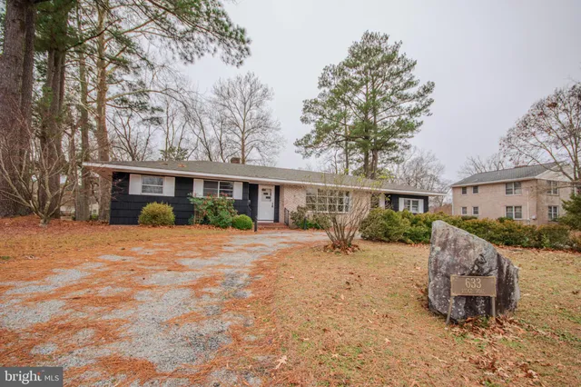 a front view of a house with a yard and seating space