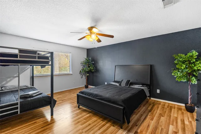 a bedroom with a bed and a potted plant on the dresser
