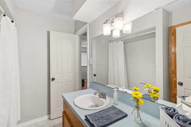 a bathroom with a granite countertop sink a mirror and a bathtub