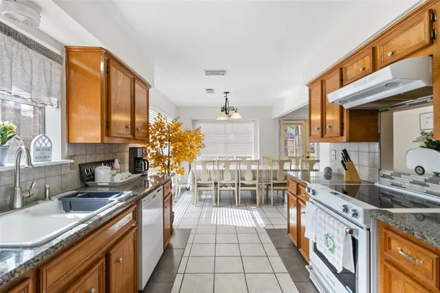 a kitchen with granite countertop a sink stove and cabinets